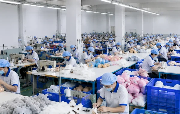 Inside a custom plush toy factory showing skilled workers producing OEM and ODM plush toys in a modern manufacturing facility